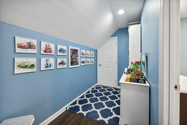 hallway featuring vaulted ceiling and dark hardwood / wood-style floors