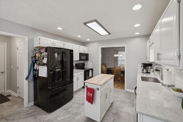 kitchen featuring wood counters, tasteful backsplash, white cabinetry, sink, and black appliances