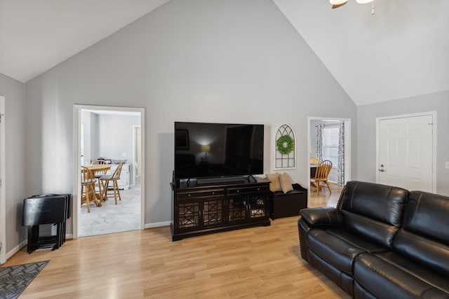 living room with high vaulted ceiling and light wood-type flooring