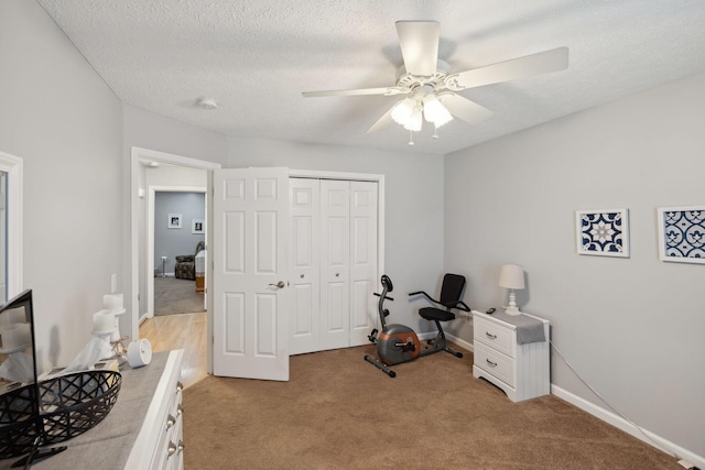 interior space featuring ceiling fan, light colored carpet, and a textured ceiling