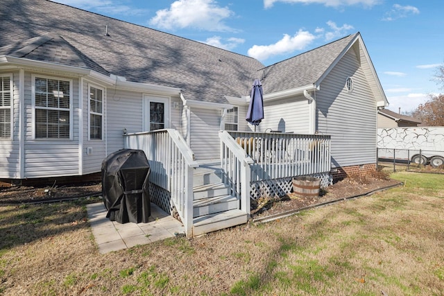 rear view of property featuring a wooden deck and a yard