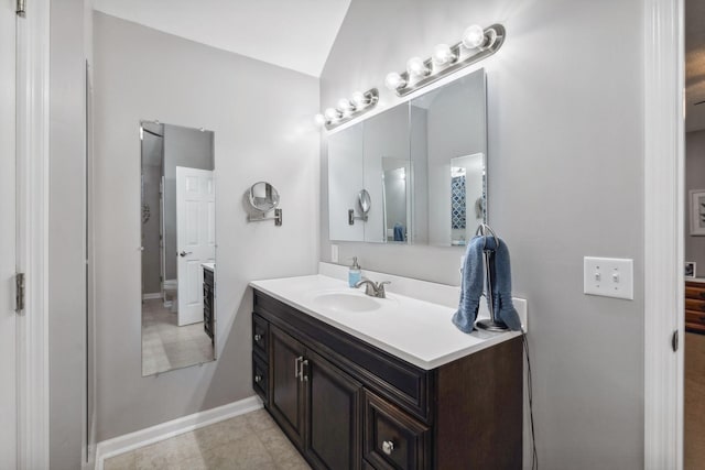 bathroom with vanity and lofted ceiling