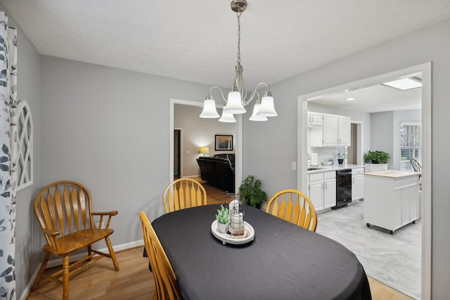 dining area with light hardwood / wood-style flooring and a notable chandelier