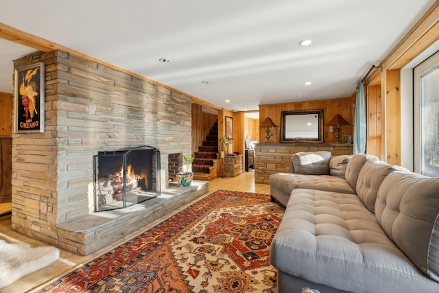 living room featuring light tile patterned floors, a fireplace, and wooden walls