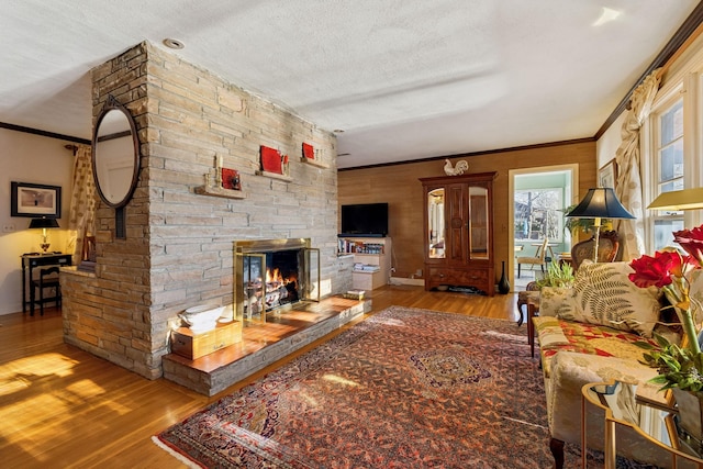 living room featuring ornamental molding, light hardwood / wood-style floors, and a textured ceiling