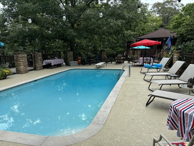 view of pool featuring a diving board and a patio