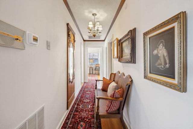 hallway with crown molding and a notable chandelier