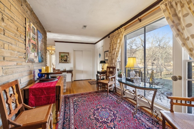 living area featuring wood-type flooring and ornamental molding