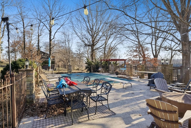 view of swimming pool featuring a diving board and a patio