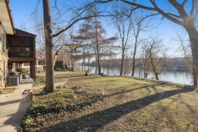 view of yard with a water view and central AC