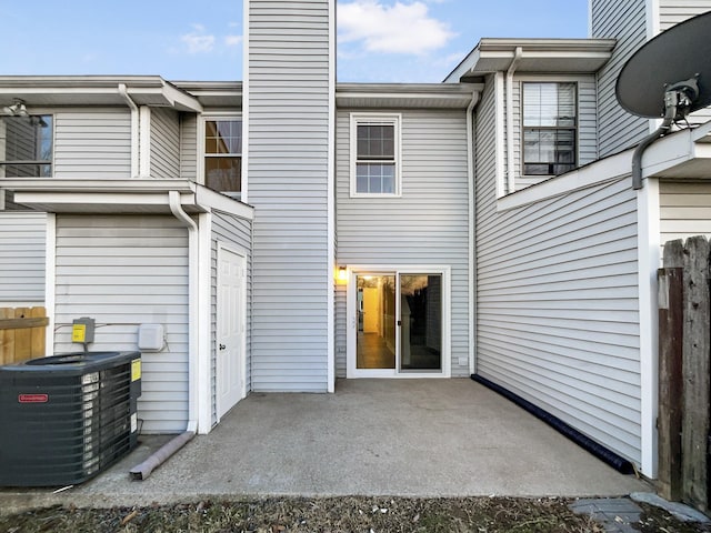 back of property with central AC and a patio