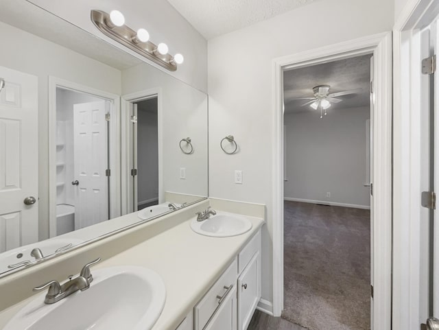 bathroom with vanity, ceiling fan, and a textured ceiling