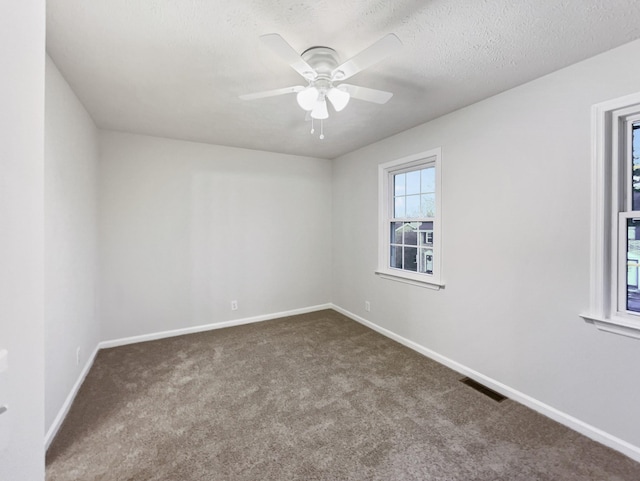 empty room featuring ceiling fan, carpet, and a textured ceiling