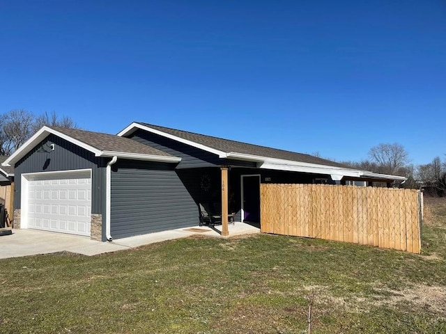 ranch-style house with a garage and a front lawn