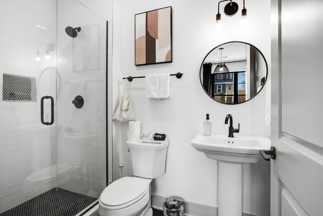 bathroom with sink, a shower with door, and toilet