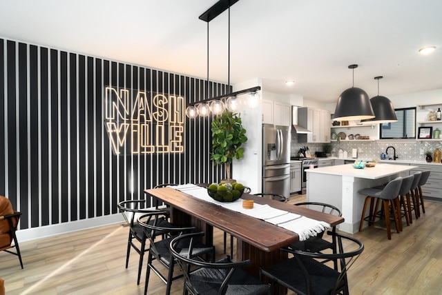 dining area with sink and light hardwood / wood-style floors