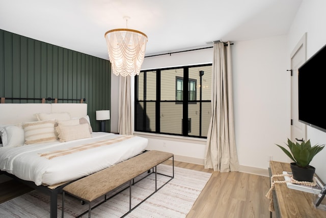 bedroom featuring an inviting chandelier and light wood-type flooring