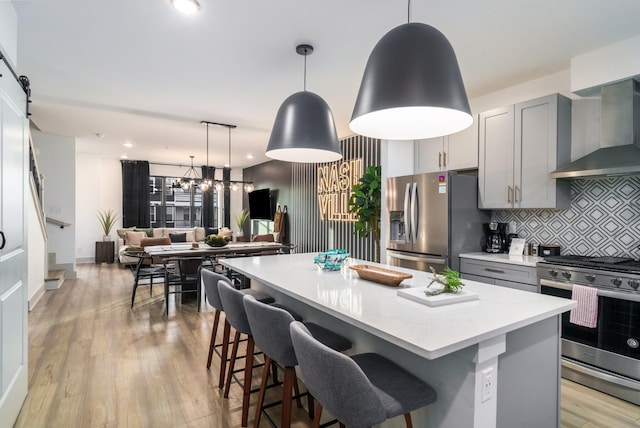 kitchen with stainless steel appliances, a kitchen island, gray cabinets, and pendant lighting