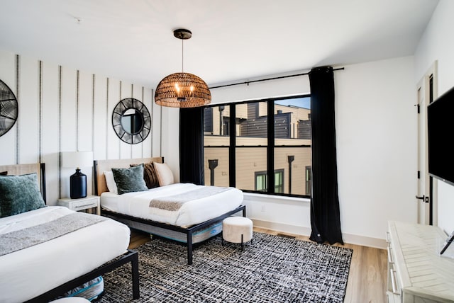 bedroom featuring an inviting chandelier and light hardwood / wood-style floors