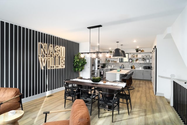 dining space featuring sink and light hardwood / wood-style flooring