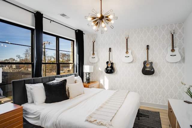 bedroom with wood-type flooring and a notable chandelier