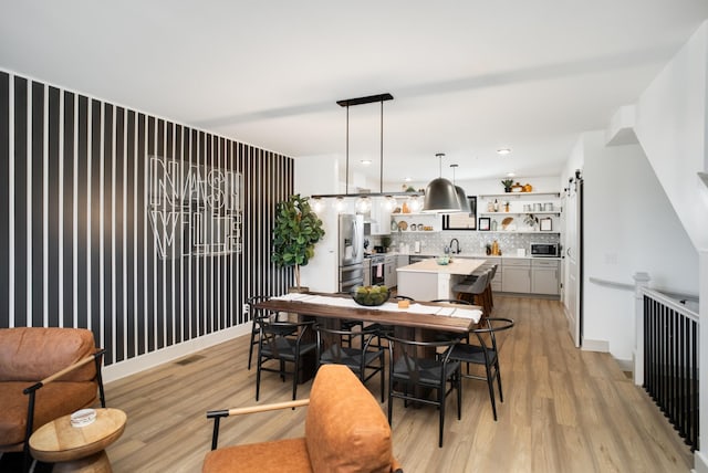 dining area with sink and light wood-type flooring