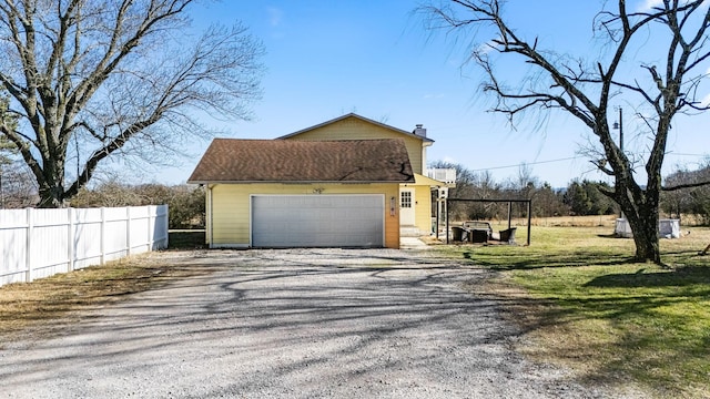 view of side of property featuring a garage, a lawn, and a carport