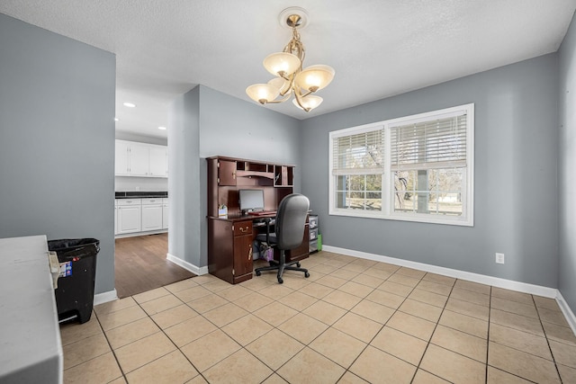 tiled office space with a textured ceiling and a chandelier