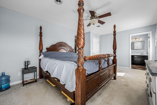 bedroom with connected bathroom, light colored carpet, and ceiling fan