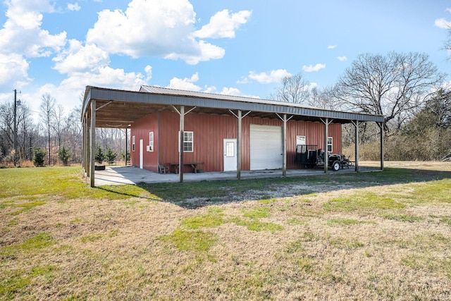 view of outbuilding featuring a garage, a yard, and a carport