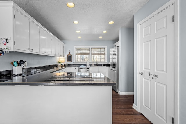 kitchen featuring white cabinetry, kitchen peninsula, and appliances with stainless steel finishes