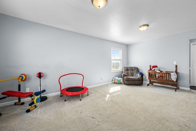 playroom with carpet and a textured ceiling