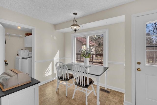 dining room featuring washing machine and dryer and a textured ceiling