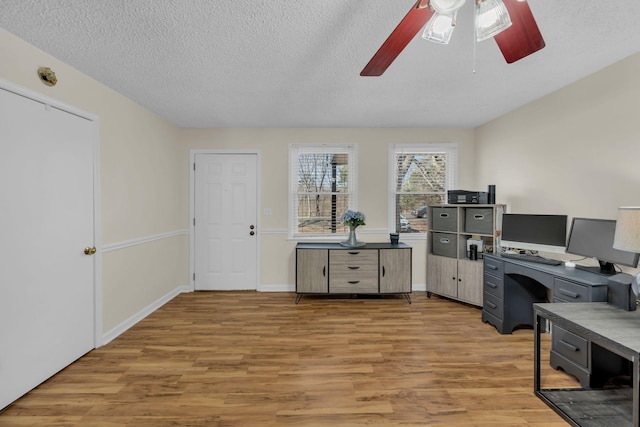 home office with ceiling fan, hardwood / wood-style floors, and a textured ceiling