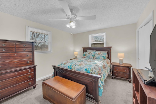 carpeted bedroom featuring ceiling fan and a textured ceiling