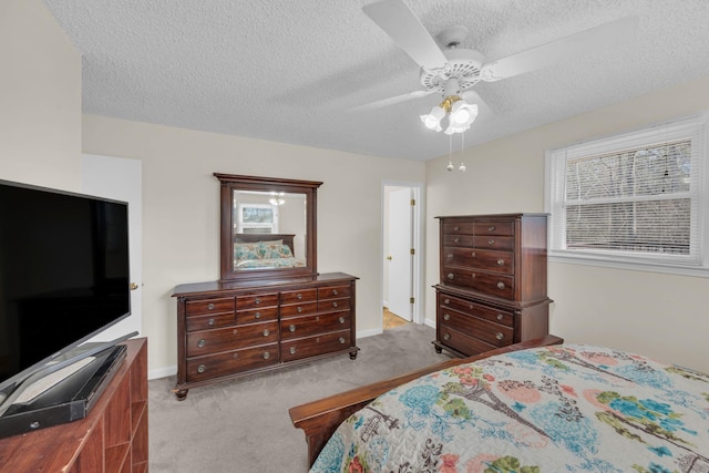 bedroom featuring light carpet, ceiling fan, and a textured ceiling