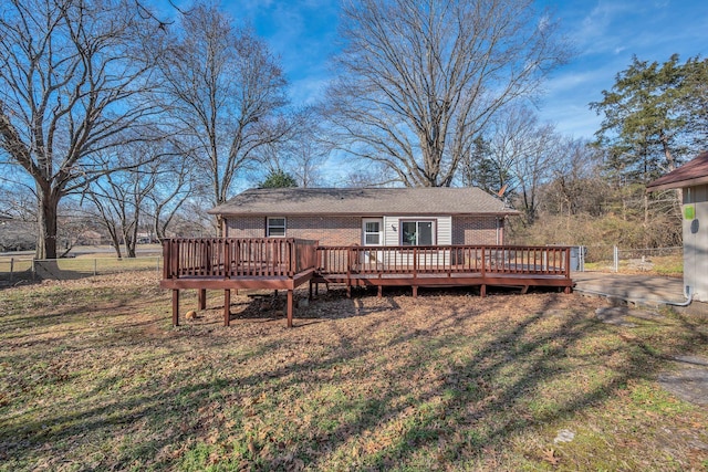 back of property with a wooden deck and a yard