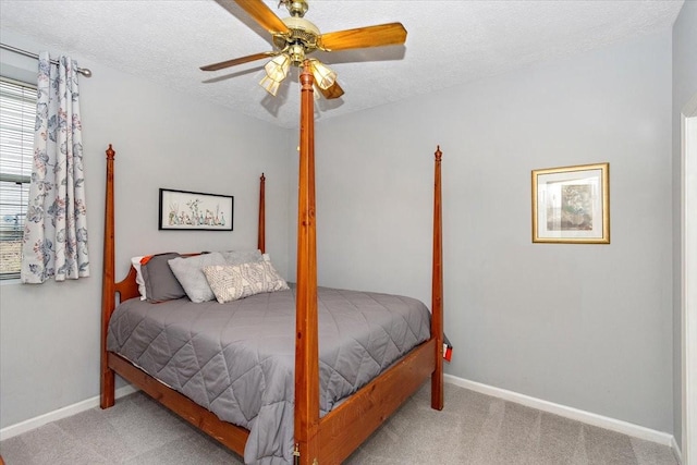 carpeted bedroom with ceiling fan and a textured ceiling