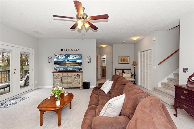 living room featuring french doors, ceiling fan, light carpet, and a textured ceiling