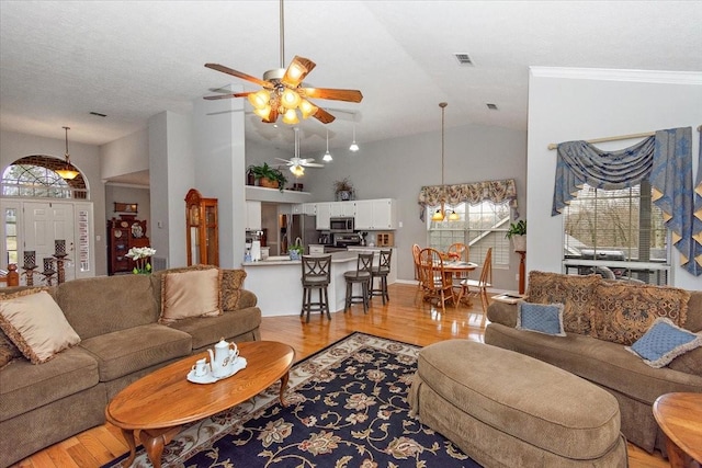 living room with ceiling fan, high vaulted ceiling, a wealth of natural light, and light hardwood / wood-style floors