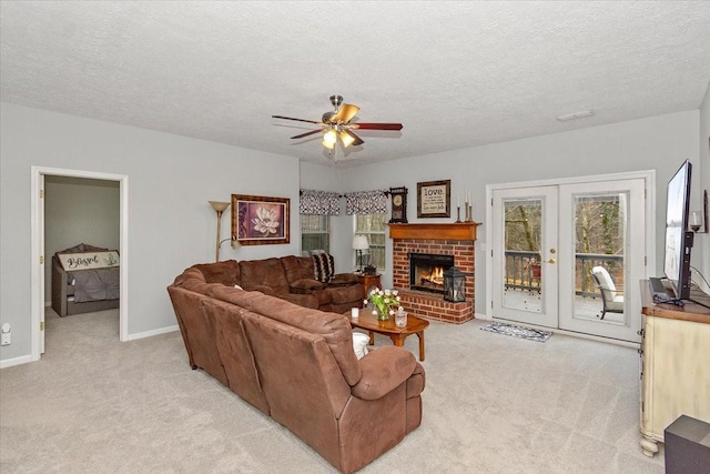 carpeted living room with ceiling fan, a textured ceiling, a fireplace, and french doors