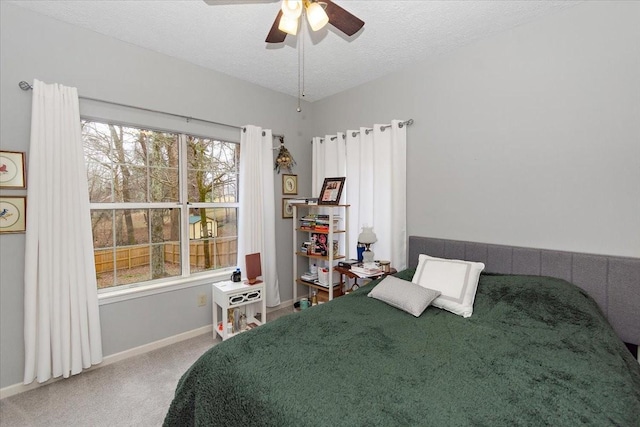 bedroom featuring ceiling fan, carpet, and a textured ceiling