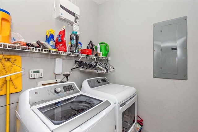 clothes washing area with electric panel and independent washer and dryer