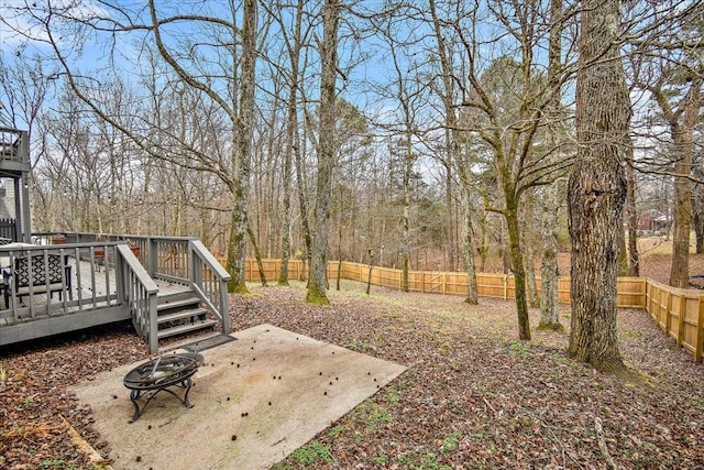 view of yard featuring a wooden deck, a patio area, and an outdoor fire pit