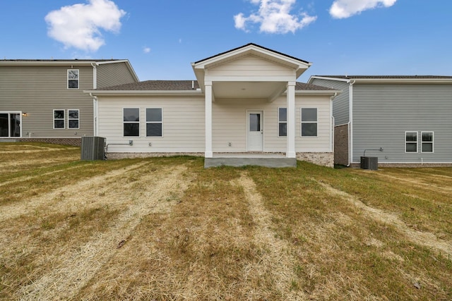 rear view of house featuring a yard, a patio, and central air condition unit