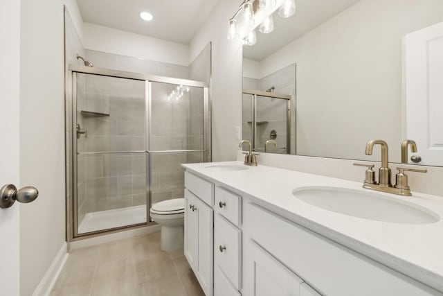 bathroom with tile patterned floors, vanity, toilet, and an enclosed shower