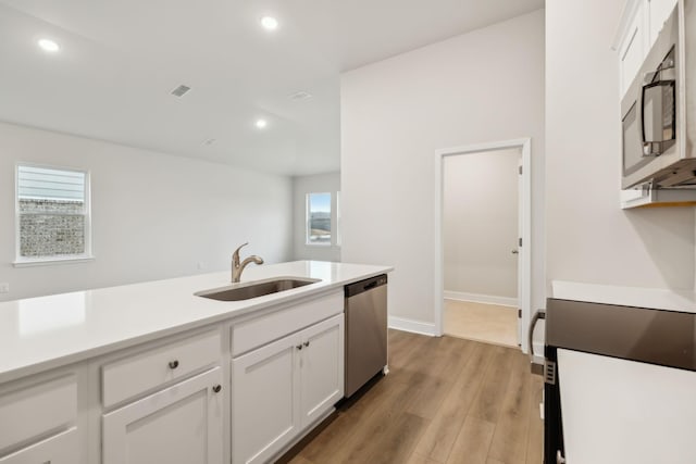 kitchen featuring white cabinetry, appliances with stainless steel finishes, sink, and light hardwood / wood-style flooring