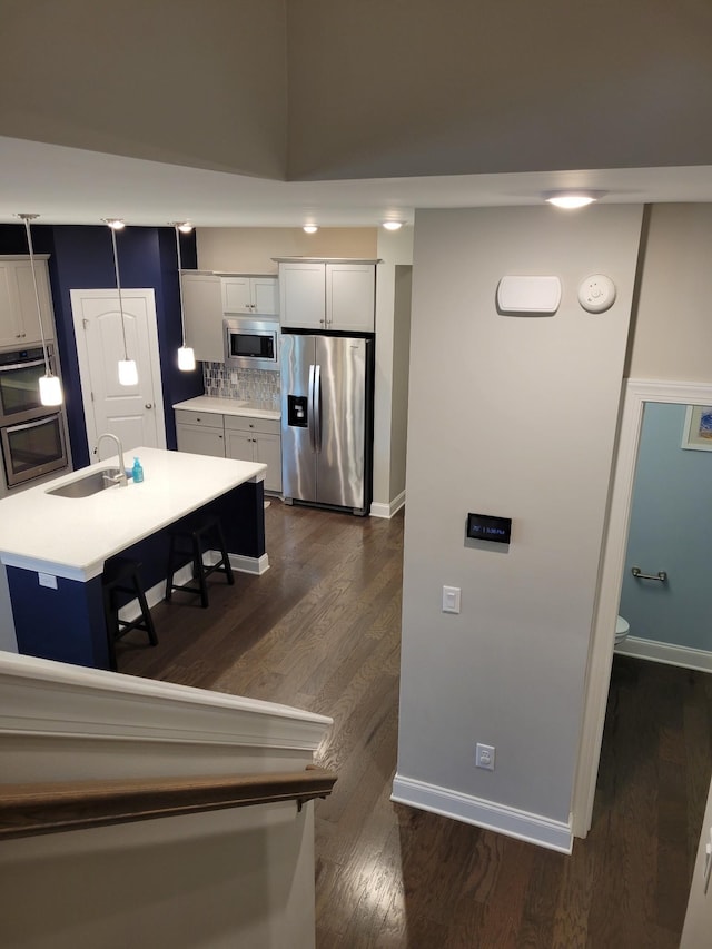 kitchen featuring white cabinetry, appliances with stainless steel finishes, a kitchen island with sink, and sink