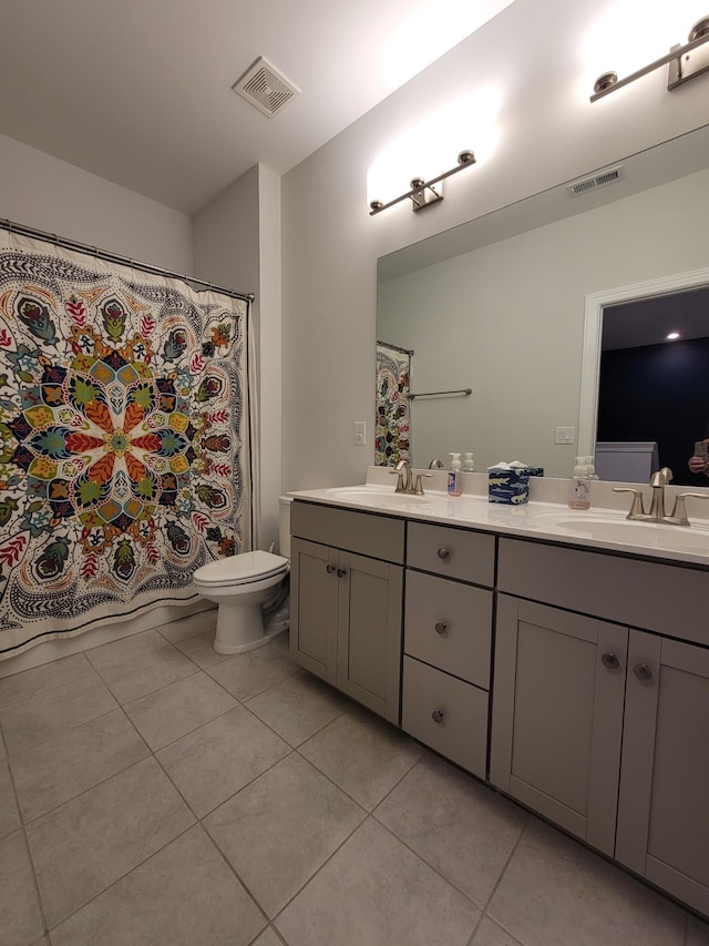 bathroom with tile patterned flooring, vanity, and toilet