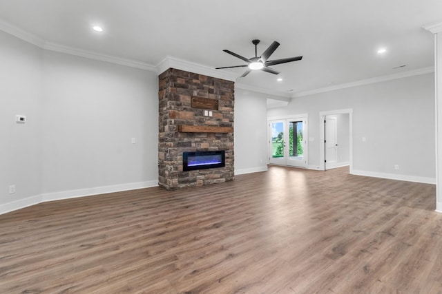 unfurnished living room with crown molding, ceiling fan, wood-type flooring, and a fireplace